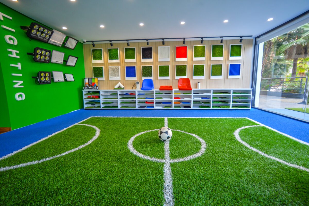 Gros plan sur un terrain de football avec gazon synthétique Proturf, montrant une texture réaliste et le marquage FIFA.